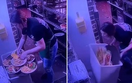 Nữ nhân viên hờn trách bản thân khi làm đổ đĩa thức ăn vào thùng
