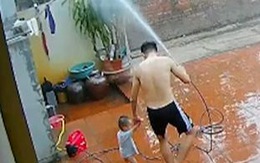 Bố cầm vòi phun nước làm mưa nhân tạo chơi cùng con
