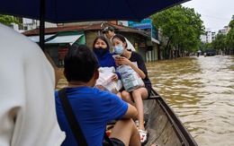 Nước lên nhanh, người dân bắt thuyền máy đi giữa TP Huế