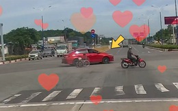 Tài xế ô tô chạy chậm dìu người đàn ông ngồi xe lăn qua đường