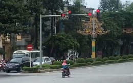 Người phụ nữ dừng xe máy chờ đèn đỏ kiểu ngược đời