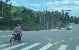 Người đàn ông dừng xe máy chờ đèn đỏ kiểu ngược đời