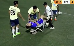 Cầu thủ bị thương được cáng ra sân bằng xe rùa