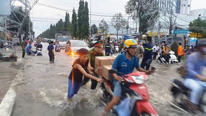 Cần Thơ nước vẫn chảy cuồn cuộn, nhiều người hì hục đẩy xe giúp dân