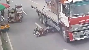 Video: Thoát chết trong gang tấc ngay dưới bánh xe container