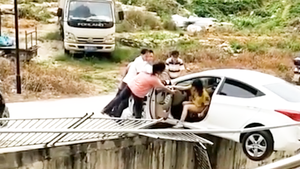 Video: Nữ tài xế lùi xe húc bay hàng rào, treo lơ lửng trên đường
