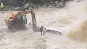 Video: Xe máy xúc giải cứu tài xế ô tô mắc kẹt giữa sông