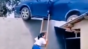 Video: Tài xế lùi ô tô lên mái nhà, người thân bắc thang 'giải cứu'
