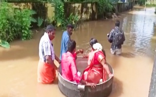 Video: Cô dâu, chú rể ngồi trong nồi nhôm vượt lũ đến nơi tổ chức đám cưới