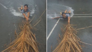 Thanh niên dùng mo cau lướt trên đường ngập ở Sài Gòn