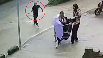 Cô gái đi xe đạp xém chết đuối vì bị té lọt xuống hố nước sâu trong cơn mưa lớn