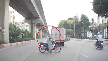 Người đàn ông đi xe máy giúp bé gái sang đường an toàn
