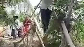 Thanh niên vác xe máy đi trên cầu khỉ