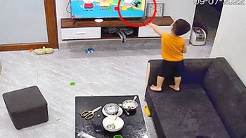Bé trai cầm đồ chơi ném vỡ màn hình tivi
