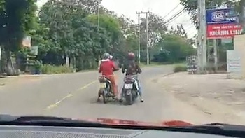 Hai người phụ nữ hồn nhiên dừng xe máy giữa đường buôn chuyện