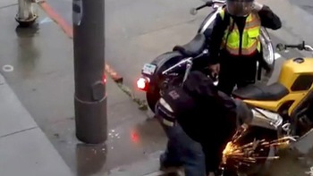 Hai thanh niên dùng máy cưa sắt cắt khóa bánh để trộm mô tô