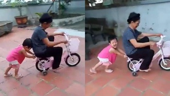 Cháu cười khoái chí khi đẩy xe đạp cho bà