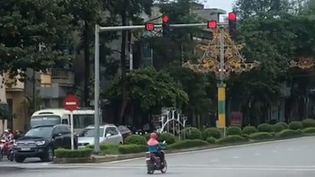 Người phụ nữ dừng xe máy chờ đèn đỏ kiểu ngược đời
