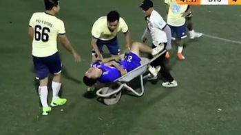 Cầu thủ bị thương được cáng ra sân bằng xe rùa