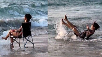 Cô gái uống nước no khi ngồi tạo dáng trước sóng biển