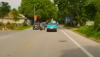 The woman rode her motorbike across the street like a superhero