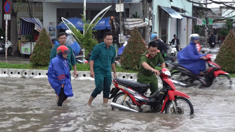 Video: Công an, dân phòng lội nước đẩy xe giúp người dân vượt triều cường