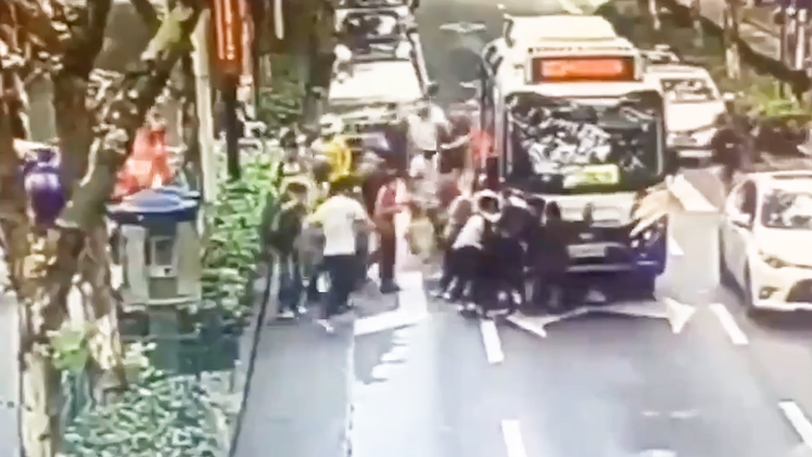 Video: Hàng chục người hợp sức cứu cô gái bị xe buýt cuốn vào gầm