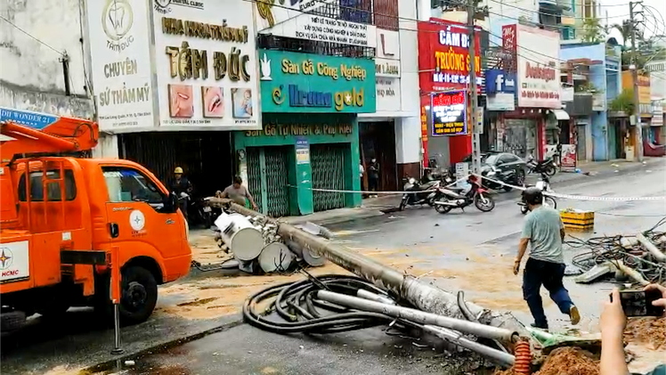 Video: Cột điện ở TP.HCM bật gốc chắn ngang đường, người dân kịp tránh tai nạn bất ngờ