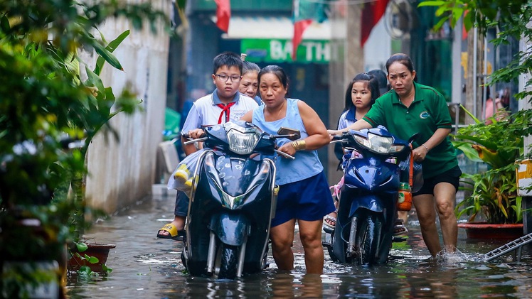 Mưa ngập chưa rút lại đến triều cường ở TP.HCM, người dân bì bõm lội nước